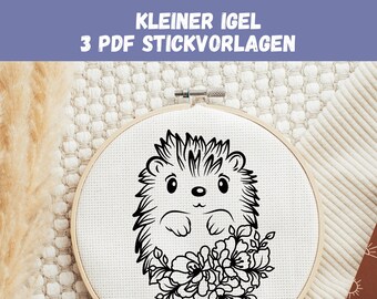 May include: Black and white embroidery pattern of a hedgehog with flowers on a white fabric background. The pattern is in a round embroidery hoop.