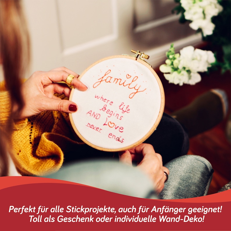 May include: A close-up of a wooden embroidery hoop with white fabric stretched across it. The fabric is embroidered with the words "family where life begins and love never ends".