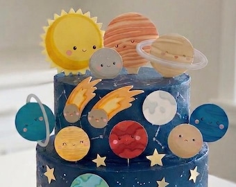 Può includere: Una torta a due piani con glassa blu scuro, decorata con topper commestibili a forma di pianeti, sole e comete. La torta presenta stelle dorate e costellazioni a linee bianche sui lati, con vari corpi celesti disposti sopra e attorno.
