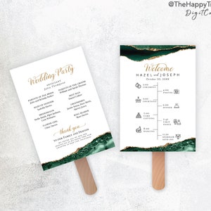 May include: Two white wedding fan programs with gold text and emerald green and gold accents. One fan reads "Wedding Party" and lists the wedding party members. The other fan reads "Welcome" and lists the wedding timeline.