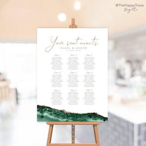 May include: A white wedding seating chart with a green and gold watercolor background. The chart lists the names of guests assigned to each table. The text at the top reads "Your seat awaits Hazel & Joseph 12 April 20XX".
