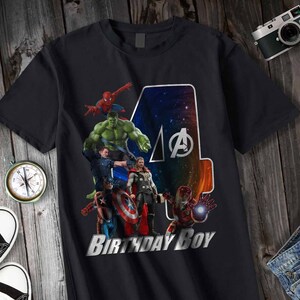 May include: Black t-shirt with a graphic of the Avengers characters, including Hulk, Spiderman, Thor, Captain America, and Iron Man. The graphic is a collage of the characters with a large number "4" in the background. The text "Birthday Boy" is printed below the graphic.