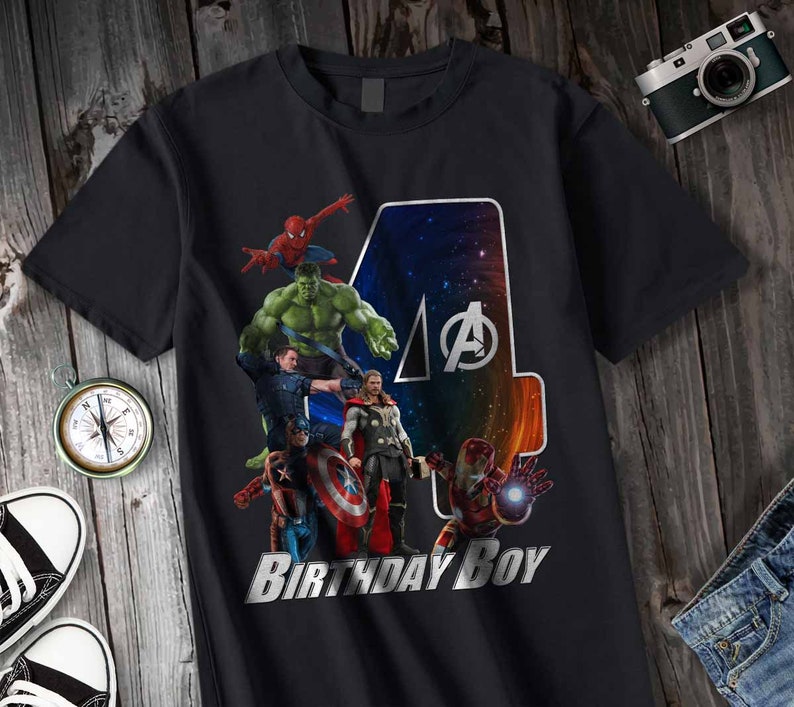 May include: Black t-shirt with a graphic of the Avengers characters, including Hulk, Spiderman, Thor, Captain America, and Iron Man. The graphic is a collage of the characters with a large number "4" in the background. The text "Birthday Boy" is printed below the graphic.