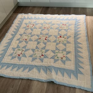 Large Double patchwork quilt with pale blue stars on white. Hand quilted