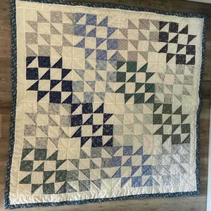 大きなダブルパッチワークキルト。パウダーブルーからネイビー、ホワイトまで、ブルーの幾何学模様を手作業でキルティングしています。