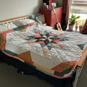 Large double patchwork quilt in a single  star pattern. Using blues corals , mustards and navy.