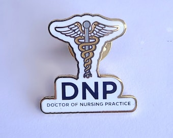 May include: Gold-colored pin with a white background. The pin features a medical caduceus symbol with a snake and wings, and the text "DNP DOCTOR OF NURSING PRACTICE".