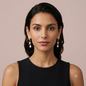 May include: A pair of drop earrings featuring a gold-toned starfish at the top, a silver-toned starfish with clear pav&eacute; stones in the middle, and a white teardrop-shaped pearl dangling at the bottom, suspended from a post-back closure.
