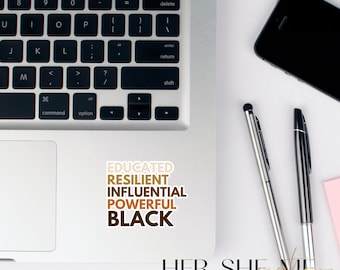 May include: A laptop computer with a sticker that reads "EDUCATED RESILIENT INFLUENTIAL POWERFUL BLACK" and the text "HER. SHE. ME. FOR THE CULTURE" on a white surface.