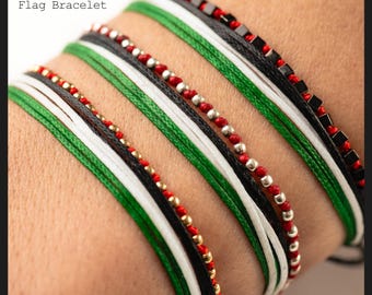 May include: Several Palestine flag bracelets are displayed, showcasing the colors of the Palestinian flag: black, white, green, and red. The bracelets feature various designs, including beaded and corded styles. The text "Palestine Flag Bracelet" is visible.