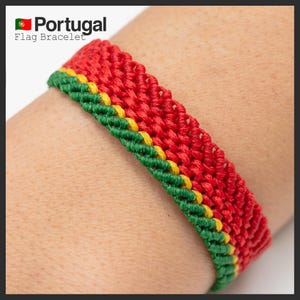Op de afbeelding: Een macramé armband met de kleuren van de Portugese vlag: rood, groen en geel. De armband wordt om de pols gedragen en heeft de tekst "Portugal Flag Bracelet" linksboven.