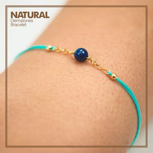 Op de afbeelding: Een turquoise armband van touw met een gouden ketting en een donkerblauwe edelsteen kraal. NATURAL Gemstones Bracelet.