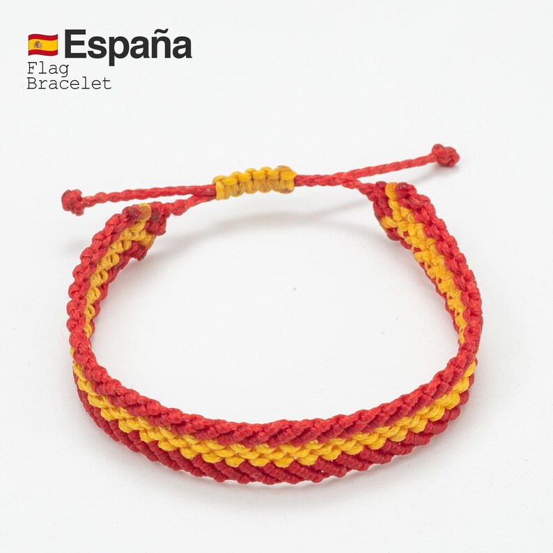 May include: Red and yellow woven bracelet, featuring the colors of the Spanish flag. The bracelet has a sliding knot closure for adjustable sizing. Text on the image reads "Espa&ntilde;a" and "Flag Bracelet".