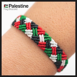 May include: A macramé bracelet displaying the Palestinian flag's colours: red, white, green, and black. The bracelet is made of interwoven threads, with the text "Palestine Flag Bracelet" in the upper left corner.