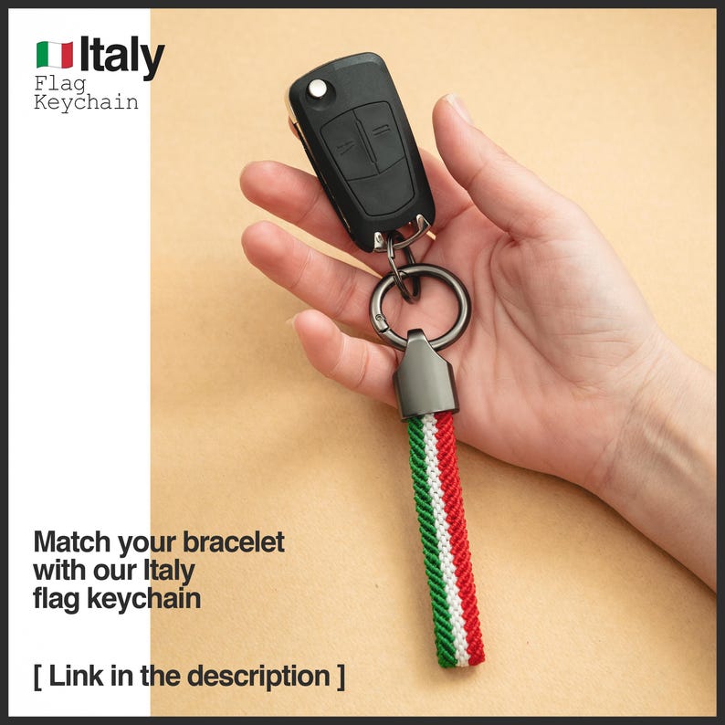 Puede incluir: Una llave de coche negra con un llavero de metal y un cord&oacute;n con los colores de la bandera italiana: verde, blanco y rojo. El llavero tiene el texto "Italy Flag Keychain". La imagen tambi&eacute;n incluye el texto "Match your bracelet with our Italy flag keychain".