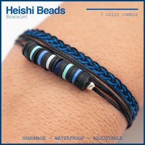 Puede incluir: Pulsera Heishi Beads hecha a mano con cordón negro y detalles trenzados azules. La pulsera presenta una pila de cuentas de disco de colores en negro, blanco, azul y turquesa. El texto dice "7 color combos", "handmade", "waterproof" y "adjustable".