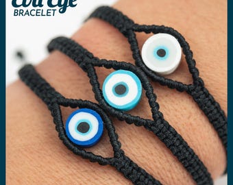 May include: Close-up of three black macrame bracelets with evil eye beads. Each bracelet features a different colored eye bead: blue, white, and light blue. The text "Evil Eye Bracelet" is in the upper left corner.