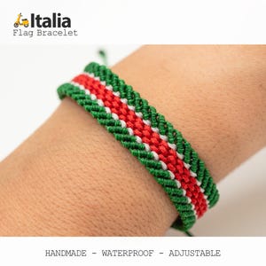 Puede incluir: Una pulsera hecha a mano, impermeable y ajustable con los colores de la bandera italiana: verde, blanco y rojo. La pulsera tejida se muestra en una mu&ntilde;eca. El texto "Italia Flag Bracelet" es visible en la esquina superior izquierda.