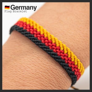 Könnte beinhalten: Ein schwarzes, rotes und gelbes Freundschaftsarmband mit den Worten "Germany Flag Bracelet" darüber.