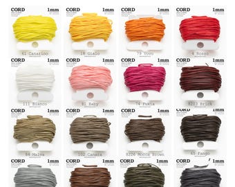Puede incluir: Un paquete de valor de cordón de macramé de 1 mm en varios colores, incluyendo amarillo, naranja, rojo, rosa, marrón y gris. La imagen muestra 16 bobinas de cordón, cada una etiquetada con un nombre y número de color. El texto "1mm VALUE PACK" está en la parte superior.
