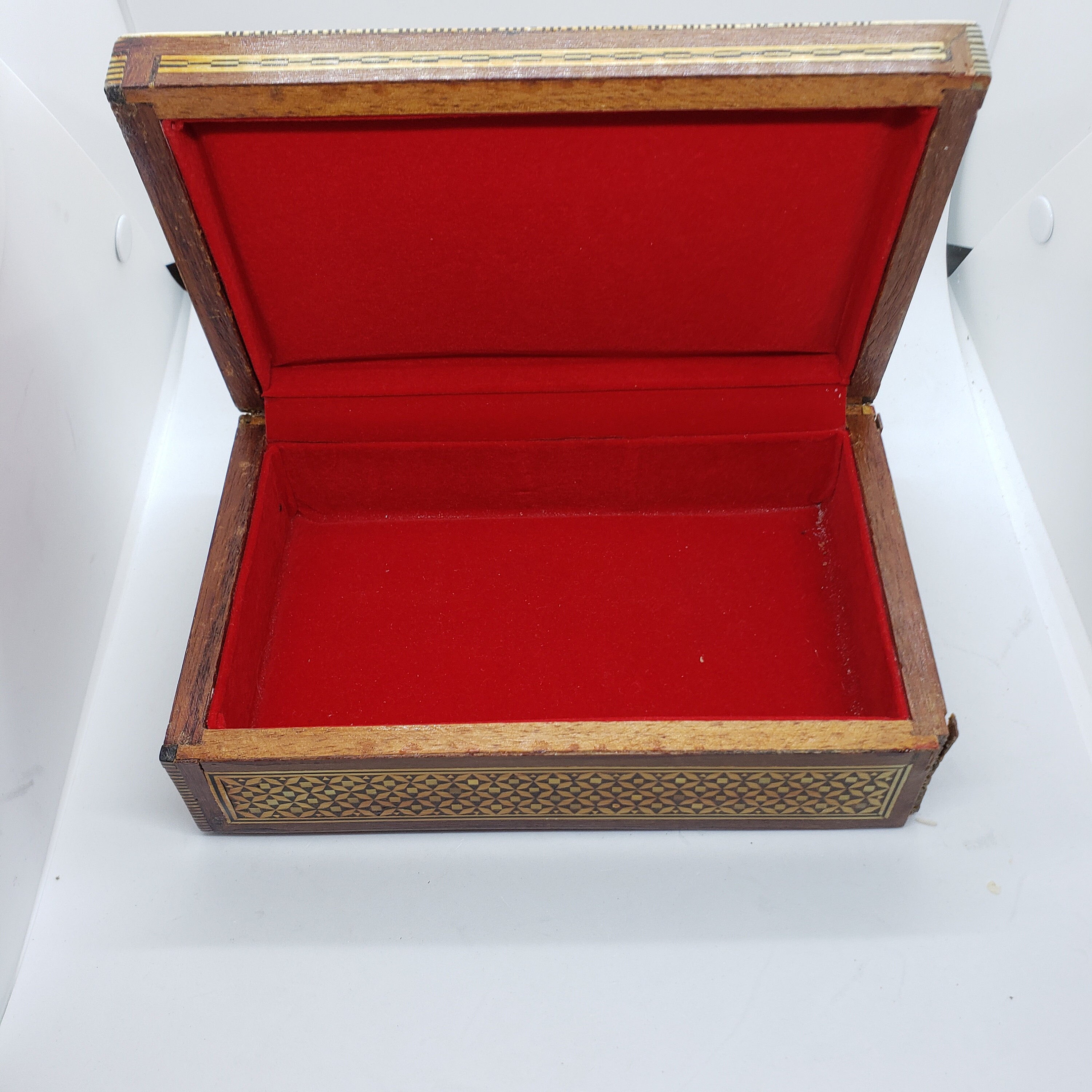 ヴィンテージの木製の蓋付き小物入れ。金と黒の幾何学模様。赤い