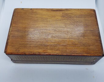 ヴィンテージの木製の蓋付き小物入れ。金と黒の幾何学模様。赤い