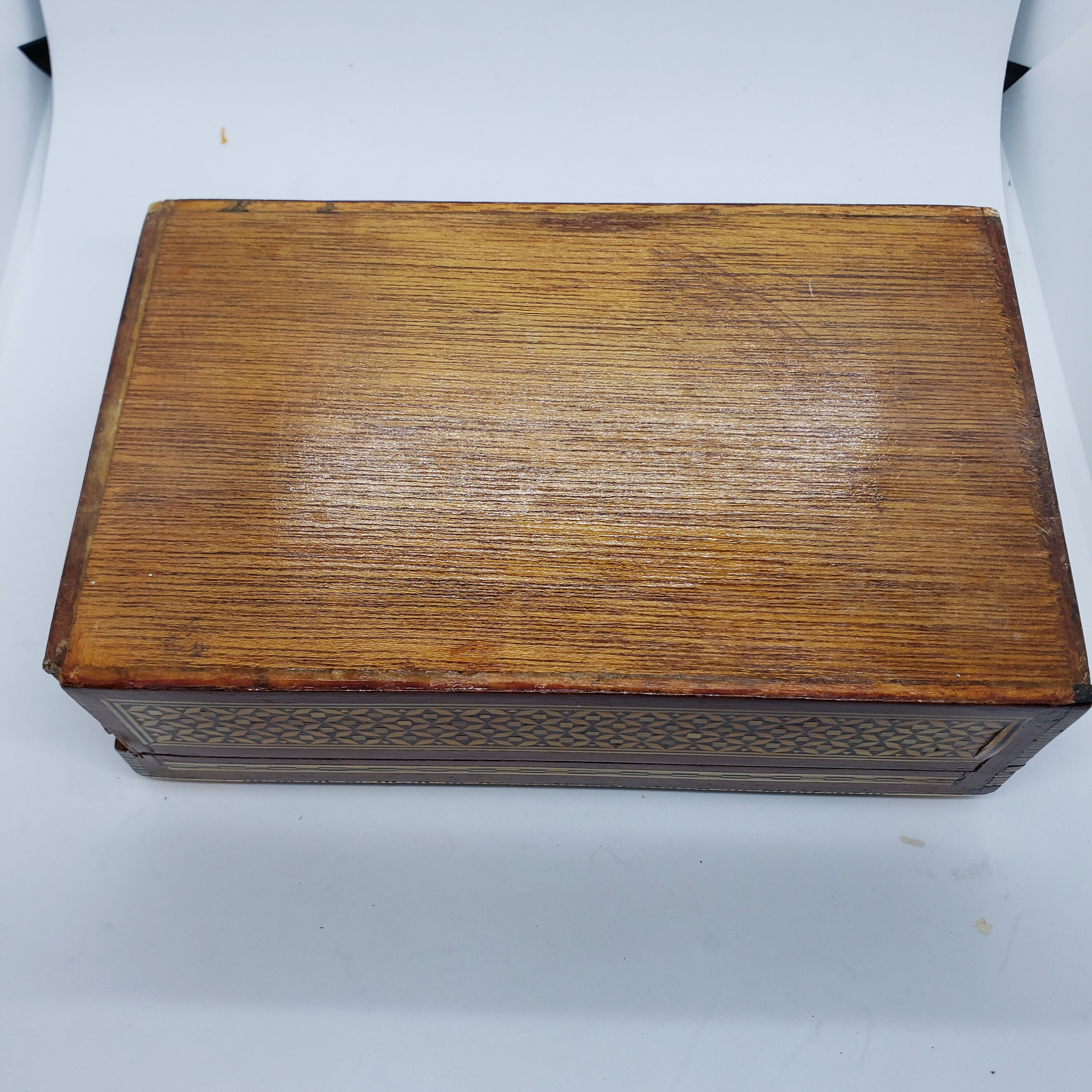 ヴィンテージの木製の蓋付き小物入れ。金と黒の幾何学模様。赤い