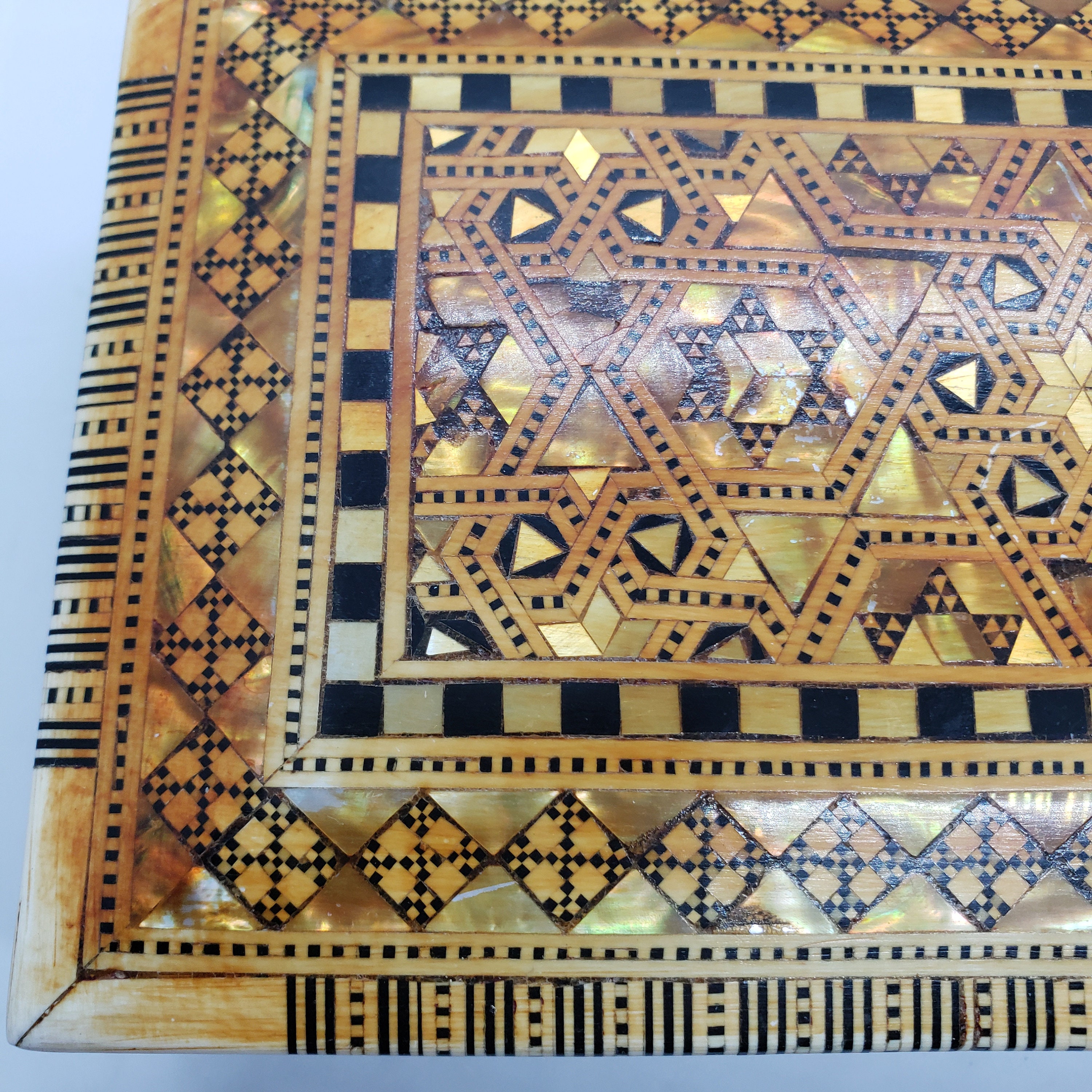 ヴィンテージの木製の蓋付き小物入れ。金と黒の幾何学模様。赤い