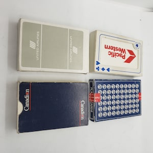 Puede incluir: Cuatro barajas de cartas vintage. Las barajas incluyen United Airlines, Pacific Western, Canadian y una baraja azul con un diseño blanco repetido. Las barajas están en sus cajas originales.