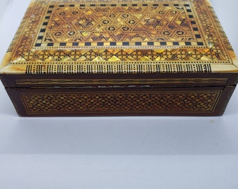ヴィンテージの木製の蓋付き小物入れ。金と黒の幾何学模様。赤い