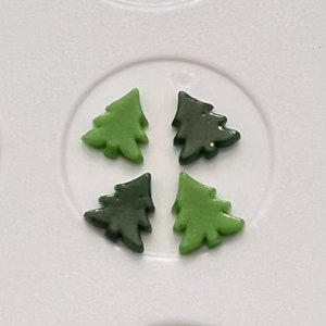 May include: Four small Christmas tree-shaped ornaments, two are green and two are dark green.