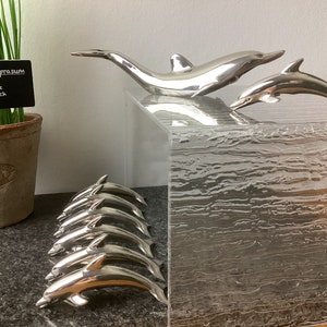 Delphin-Messerbänke, Namenskartenhalter, Menükartenhalter mit Flaschenöffner, hergestellt um 1970, aus Metall blanc