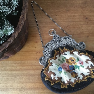 May include: A vintage embroidered purse with a silver chain and ornate silver clasp. The purse is decorated with a floral pattern in shades of yellow, pink, blue, and green.