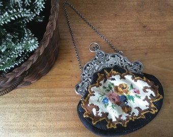 May include: A vintage embroidered purse with a silver chain and ornate silver clasp. The purse is decorated with a floral pattern in shades of yellow, pink, blue, and green.