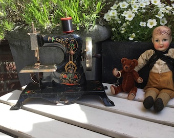 Antique sewing machine children's toy made in the late 1930s, collector's item Art Dec - decorated with flowers and gold-colored lines