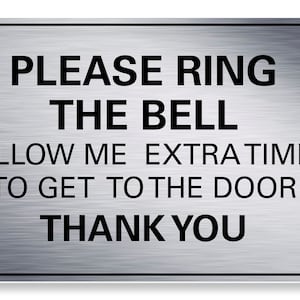 May include: A silver metal sign with the text "PLEASE RING THE BELL ALLOW ME EXTRA TIME TO GET TO THE DOOR THANK YOU".
