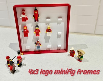 May include: A red 4x3 Lego minifigure frame with a white background and 12 slots for minifigures. The frame is made of plastic and has a red border. There are several Lego minifigures in the frame, including a red pepper, a chef, a soccer player, and a lumberjack. There are also several Lego minifigures outside of the frame.
