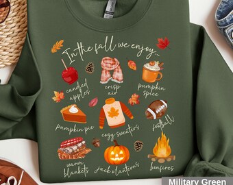 May include: Military green sweatshirt with the text "In the fall we enjoy..." and illustrations of fall-themed items like a pumpkin pie, cozy sweater, and jack-o'-lanterns. The sweatshirt is a comfortable, casual style.