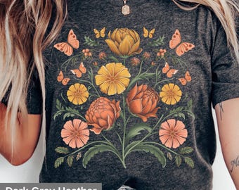 May include: Dark grey heather t-shirt with a floral print featuring yellow, orange, and pink flowers and butterflies.