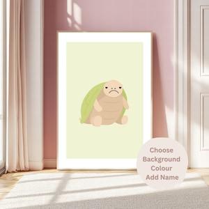 Può includere: Una stampa artistica incorniciata raffigurante una tartaruga dei cartoni animati con un'espressione triste. La tartaruga ha un guscio verde e un corpo beige, su uno sfondo verde chiaro. La stampa è in una cornice di legno, con un bordo bianco. Il testo sull'immagine dice "Choose Background Colour Add Name".