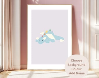 May include: A framed print featuring a light blue cartoon dinosaur with white cloud accents and colorful details. The artwork is set against a pale purple background. The print is displayed in a room with a pink wall and a white door. Text on the image says "Choose Background Colour Add Name".