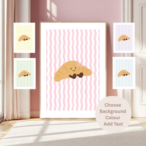May include: A framed wall art print featuring a tan cartoon croissant with a small pink bow and dark brown feet, centred on a vertical pink and white wavy striped background. A circular text overlay reads Choose Background Colour Add Text.