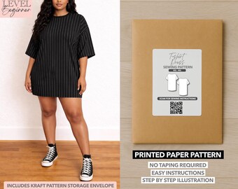 May include: A woman wearing a black and white striped t-shirt dress and black high-top sneakers. Next to her is a brown paper pattern envelope with a white label that reads "T-shirt Dress Sewing Pattern". The envelope also states "Printed Paper Pattern".