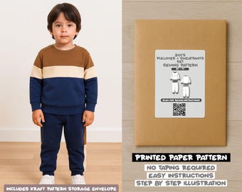 May include: A young child wearing a color-block sweatshirt and matching sweatpants. The sweatshirt is brown, cream, and navy blue. A kraft paper envelope with a sewing pattern label is on the right. The label reads "BOYS PULLOVER + SWEATPANTS SET SEWING PATTERN".