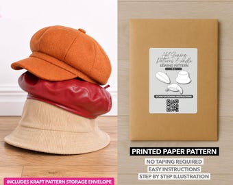 May include: An orange newsboy cap, a red beret, and a tan bucket hat are stacked. A brown paper pattern envelope with a label that reads "Hat Sewing Patterns & Bundle Sewing Pattern" is on the right. The text "Printed Paper Pattern" is below.