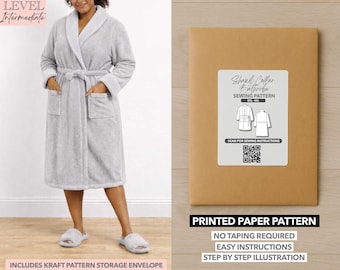 Peut inclure: Un peignoir gris clair à manches longues avec un col châle, des poches et une ceinture assortie. L'image montre également une enveloppe en papier kraft avec une étiquette indiquant "Shawl Collar Bathrobe Sewing Pattern". Le texte "Printed Paper Pattern" est également visible.