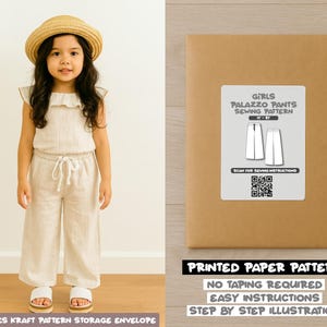 May include: A young girl wearing a beige linen jumpsuit and a straw hat. The outfit includes a top with ruffled sleeves and wide-leg pants. Beside her is a brown paper envelope with a label that reads "Girls Palazzo Pants Sewing Pattern". The text "Printed Paper Pattern" is also visible.