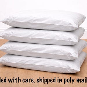 Stack of poly mailer bags with folded paper sewing pattern ready to ship.