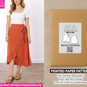 Può includere: Una donna indossa una gonna a portafoglio color ruggine e un top bianco. L'immagine mostra anche una busta di carta kraft con l'etichetta "Ruffle Hem Wrap Skirt Sewing Pattern". Il modello include un codice QR e il testo "Printed Paper Pattern".