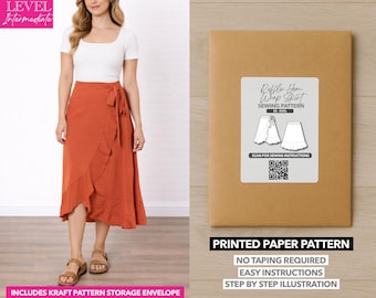 Op de afbeelding: Een vrouw draagt een roestkleurige wikkelrok en een witte top. De afbeelding toont ook een kraftpapieren envelop met het opschrift "Ruffle Hem Wrap Skirt Sewing Pattern". Het patroon bevat een QR-code en de tekst "Printed Paper Pattern".